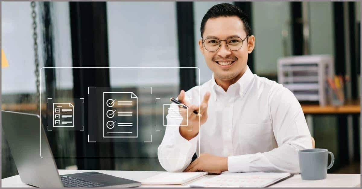 Person in white shirt pointing at floating digital document icons above a laptop on a desk in an office setting